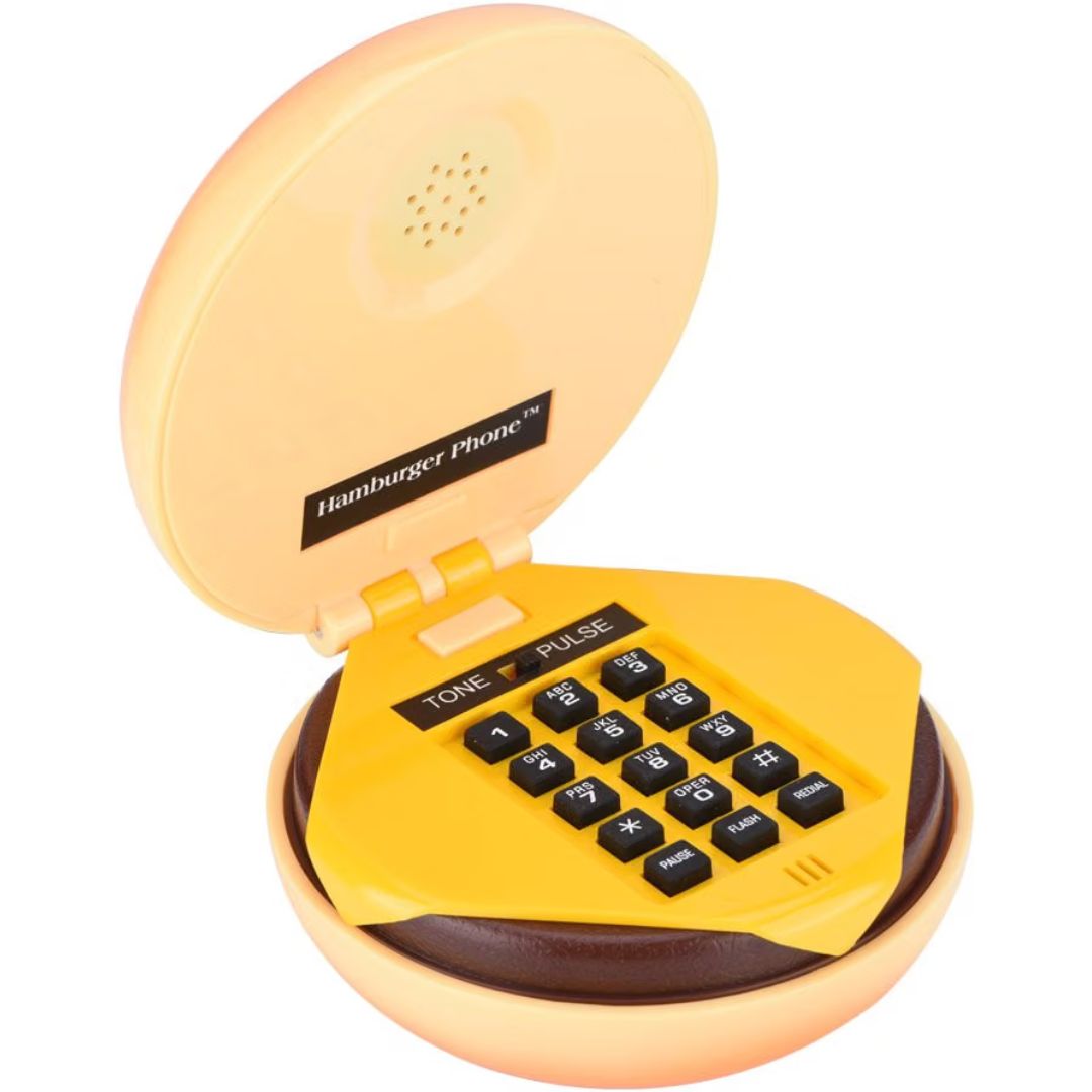 A toy hamburger phone with a yellow cheese slice dial pad, black buttons, and a peach-colored plastic outer bun shell, shown open on a white background.
