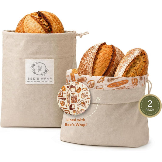 A 2 pack of reusable beeswax bread bags with a loaf of sourdough in each bag
