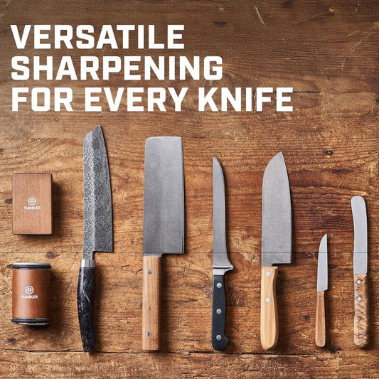 Various different knives with a rolling knife sharpener on a wooden background