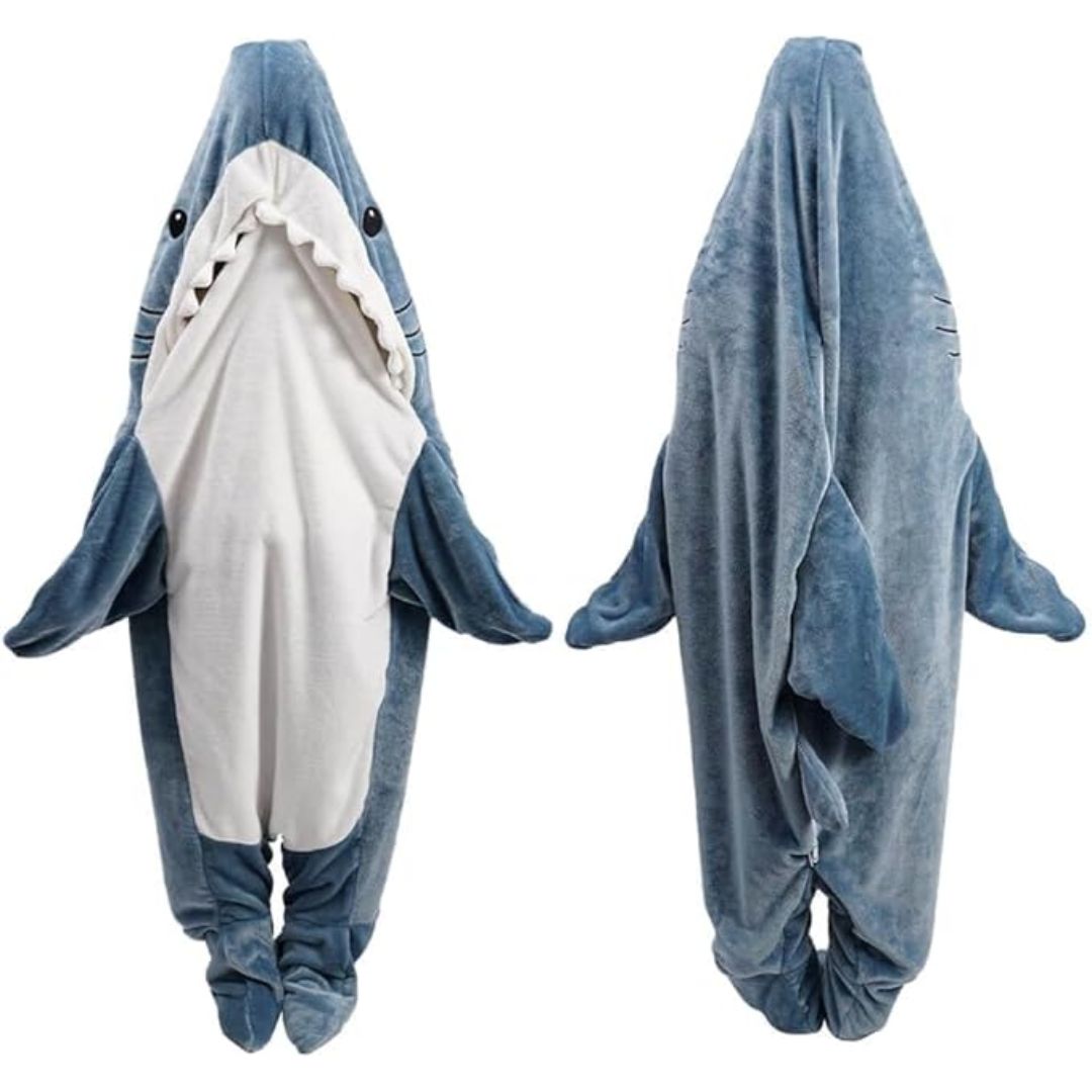 A plush shark onesie shown from the front and back on a plain white background. The one-piece hooded outfit is light blue with darker blue edges, a white belly panel, and small black eyes with white teeth on the front.