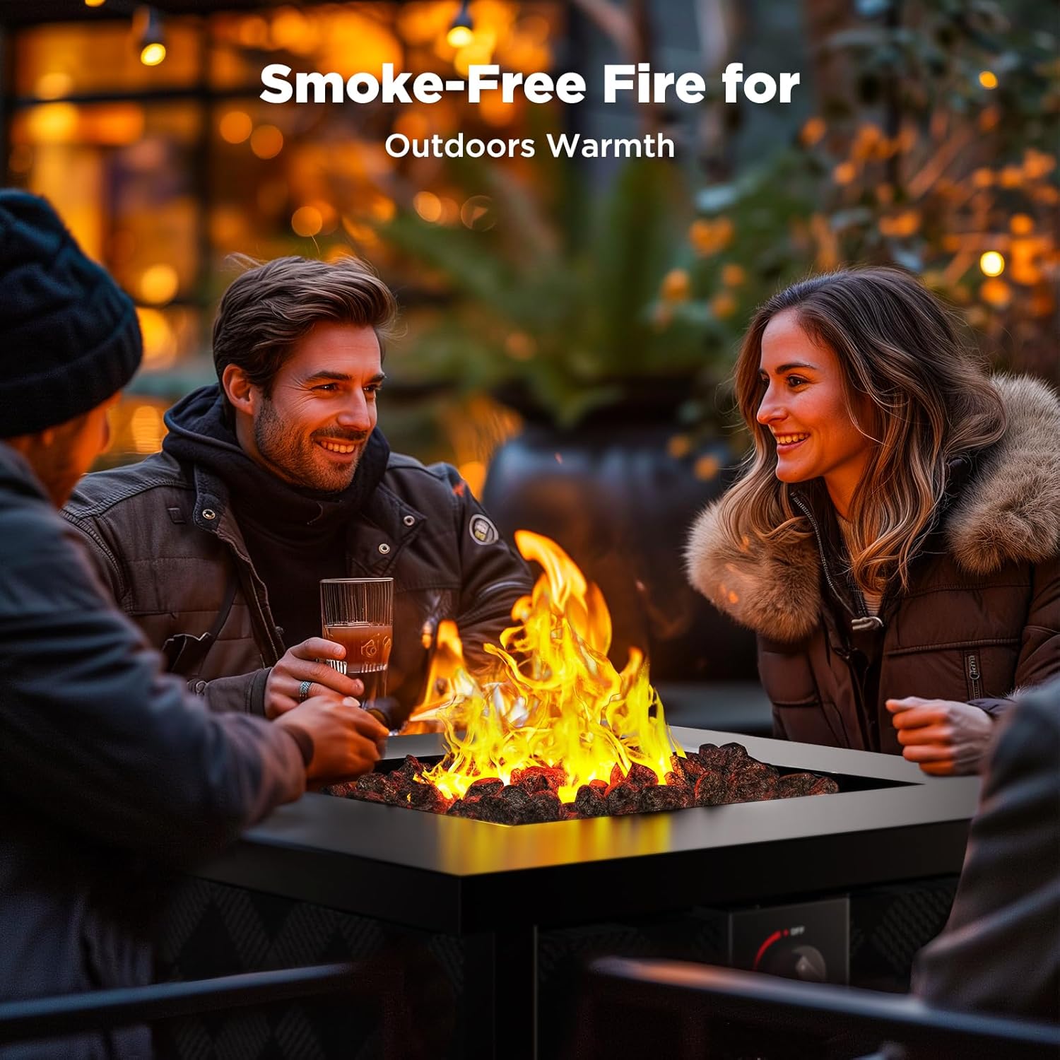 Group of friends sitting around a smokeless fire pit outdoors, smiling and enjoying drinks in a cozy evening setting with warm lighting.