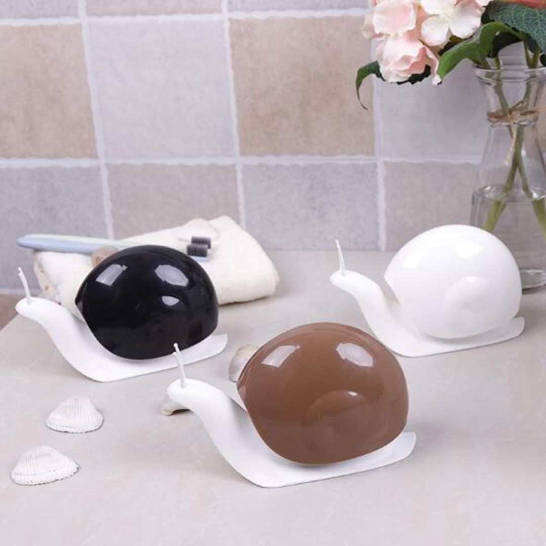Snail-shaped soap dispensers with different colored shells on a tiled surface.