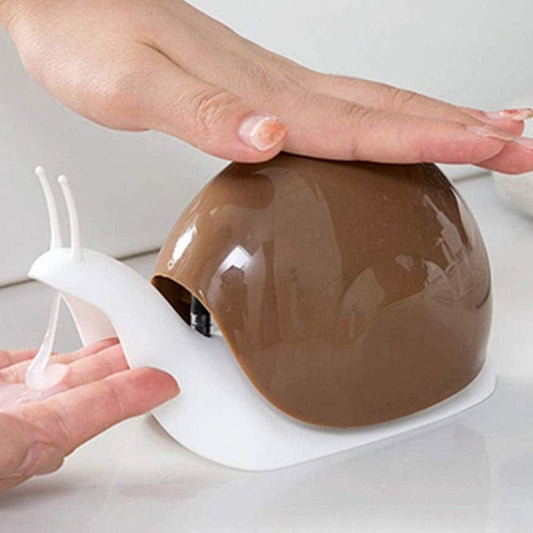 Snail-shaped soap dispenser with brown shell and white base dispensing soap on a hand.