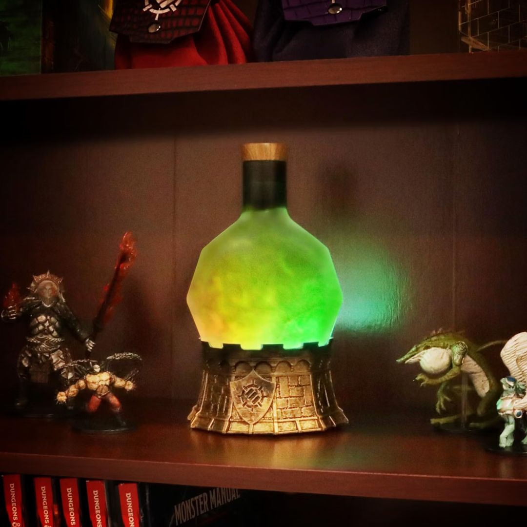 A glowing fantasy potion bottle night light with a green and yellow liquid-like body, set on a decorative gold base on a wooden shelf.