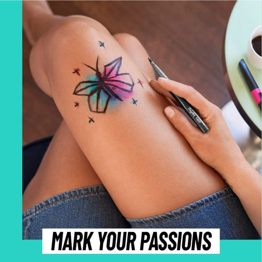 A person has drawn a colorful butterfly on their leg using a temporary tattoo marker.