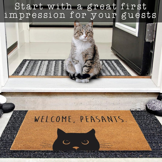 Cat sitting in a doorway in front of a mat with 'Welcome, Peasants' text and a cat illustration.