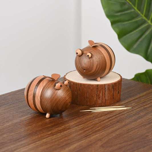 Two wooden bee-shaped toothpick holders on a brown table.