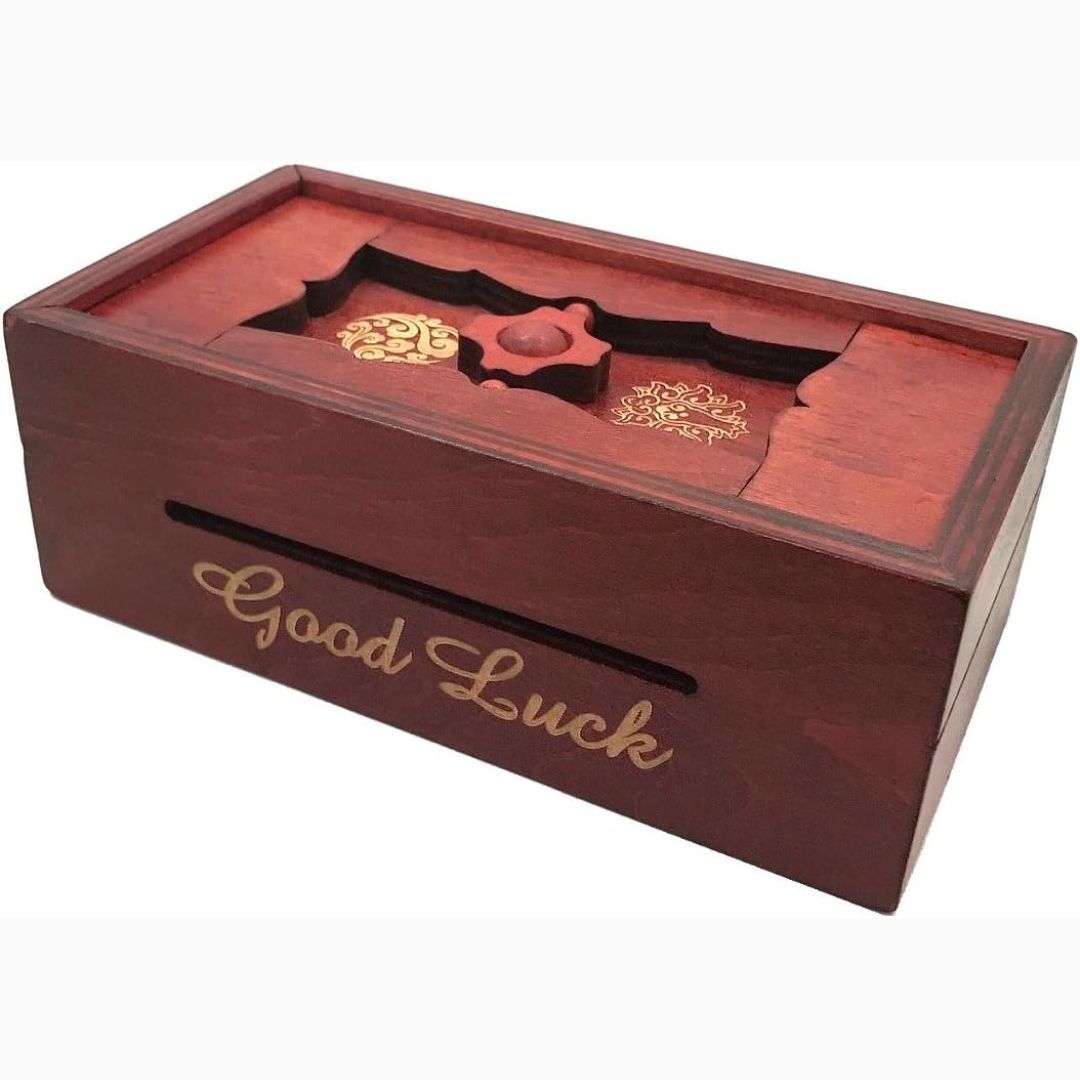 A wooden secret puzzle box inscribed with the words 'Good Luck'.