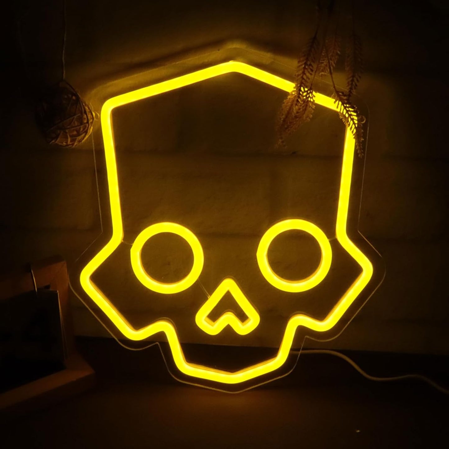 Neon yellow skull-shaped LED sign on a dark background