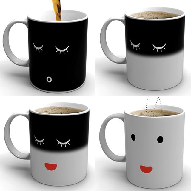 Black and white heat-reactive coffee mug changing from a sleepy face to a smiling face