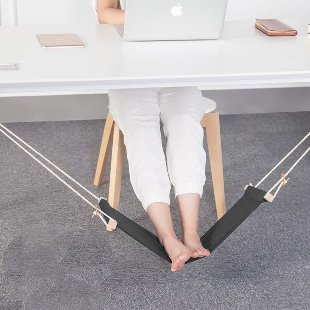 Under-desk foot hammock supporting someone's feet beneath an office desk