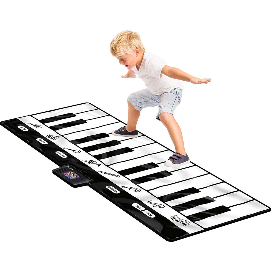 Child playing a gigantic floor piano keyboard with his feet