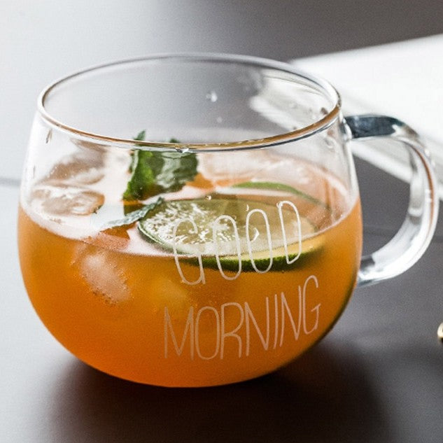 A glass mug with iced tea and a slice of lime in it