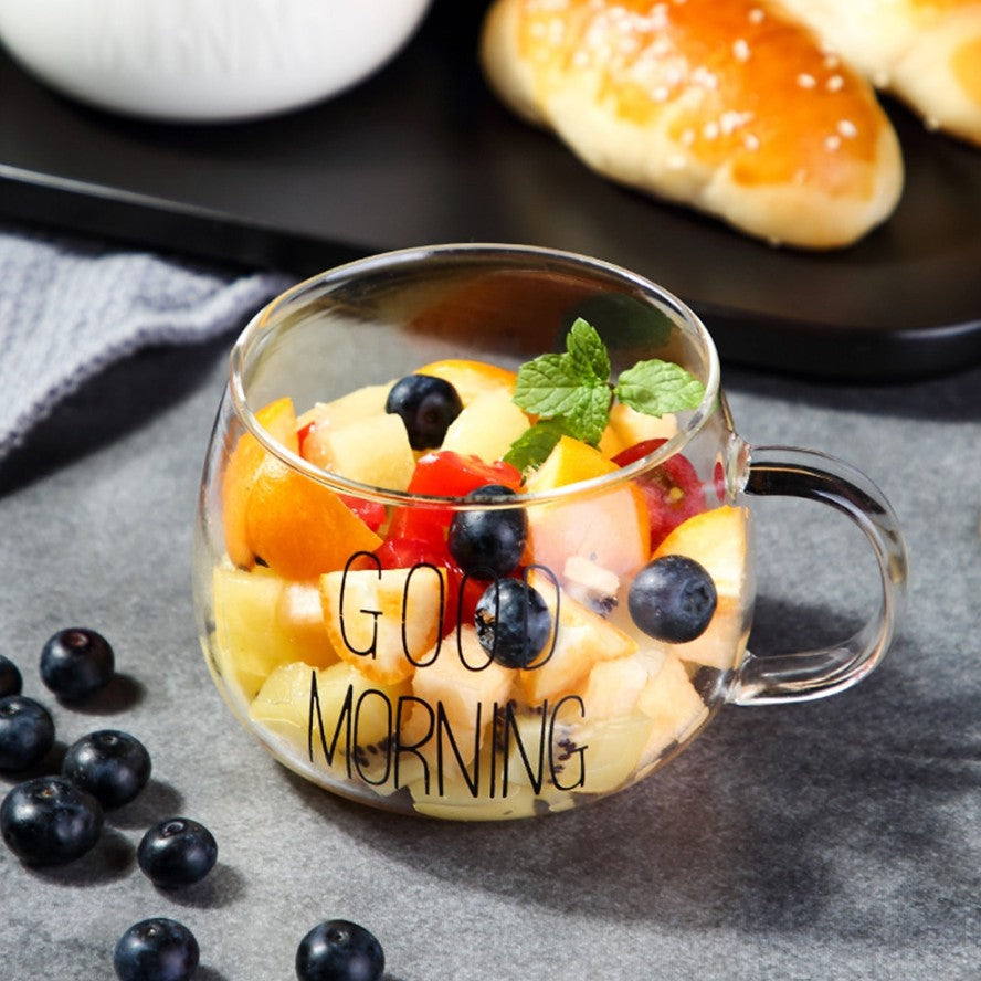 Fruit salad inside a glass mug which has good morning written on it
