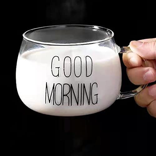 A glass cup with good morning written in black on it held by a hand
