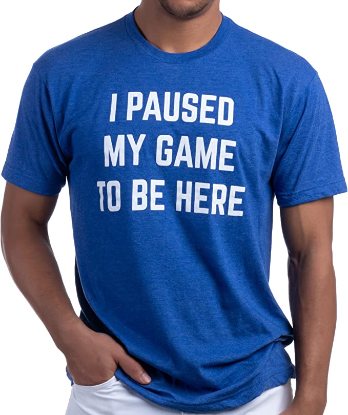 A man is wearing a blue t-shirt with the words, 'I paused my game to be here' printed on it.