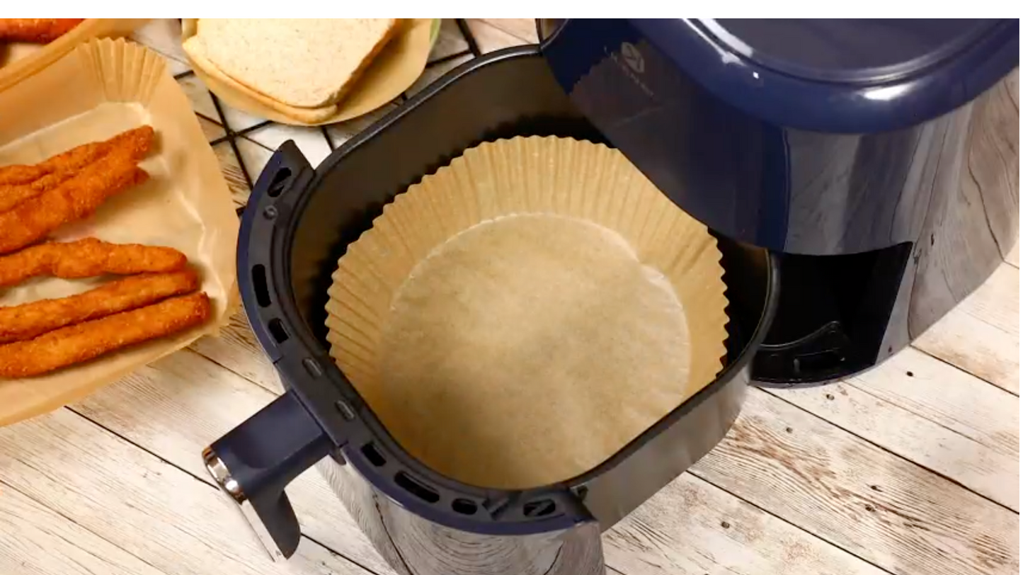 An air fryer paper liner inside the basket of an air fryer.