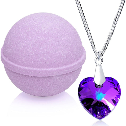 A lavender colored bath bomb with a purple heart shaped necklace next to it.