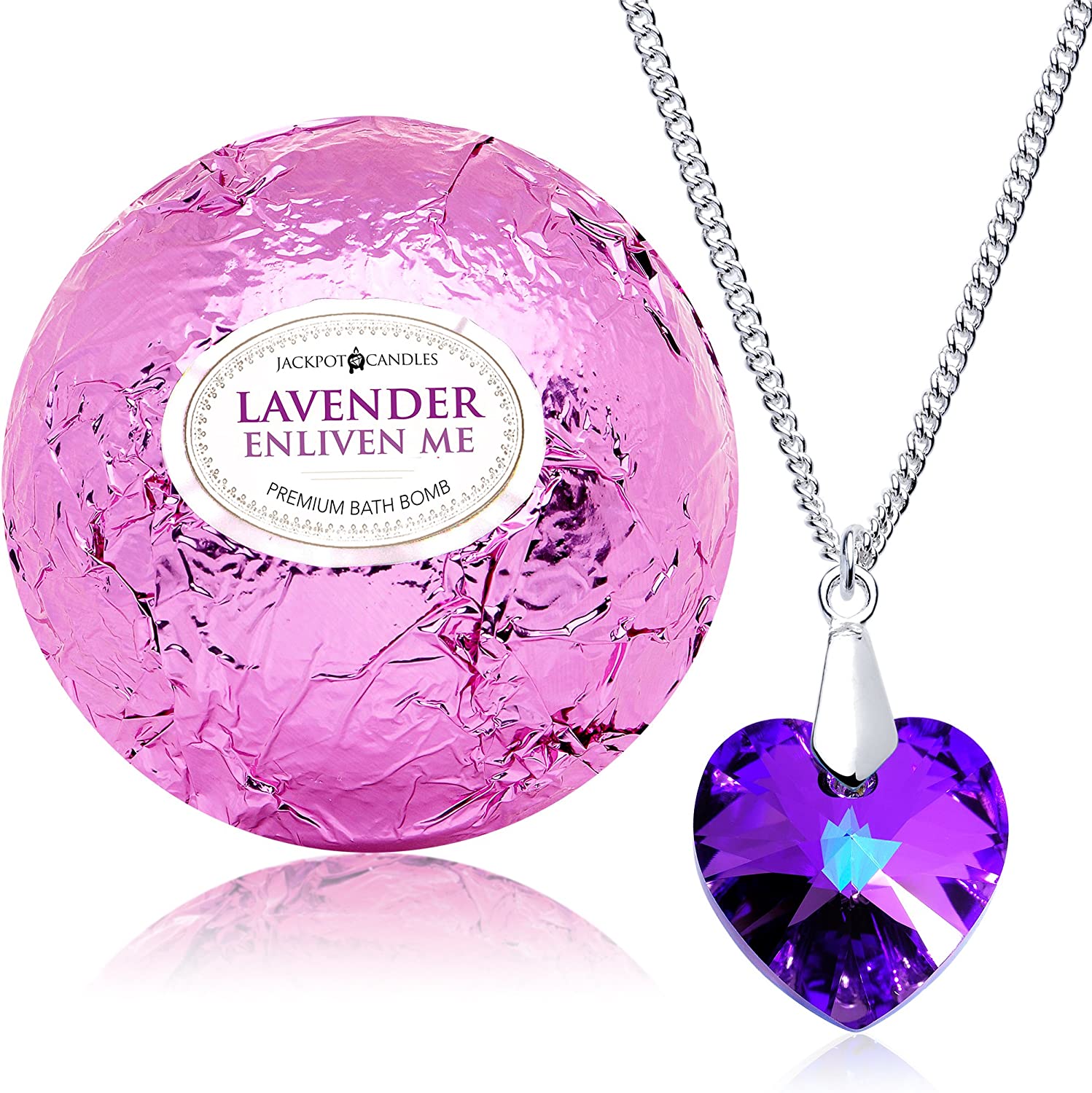 A bath bomb wrapped in purple foil with text that says, 'Lavender Enliven Me. Premium Bath Bomb.' There is a purple heart shaped necklace next to the bath bomb.