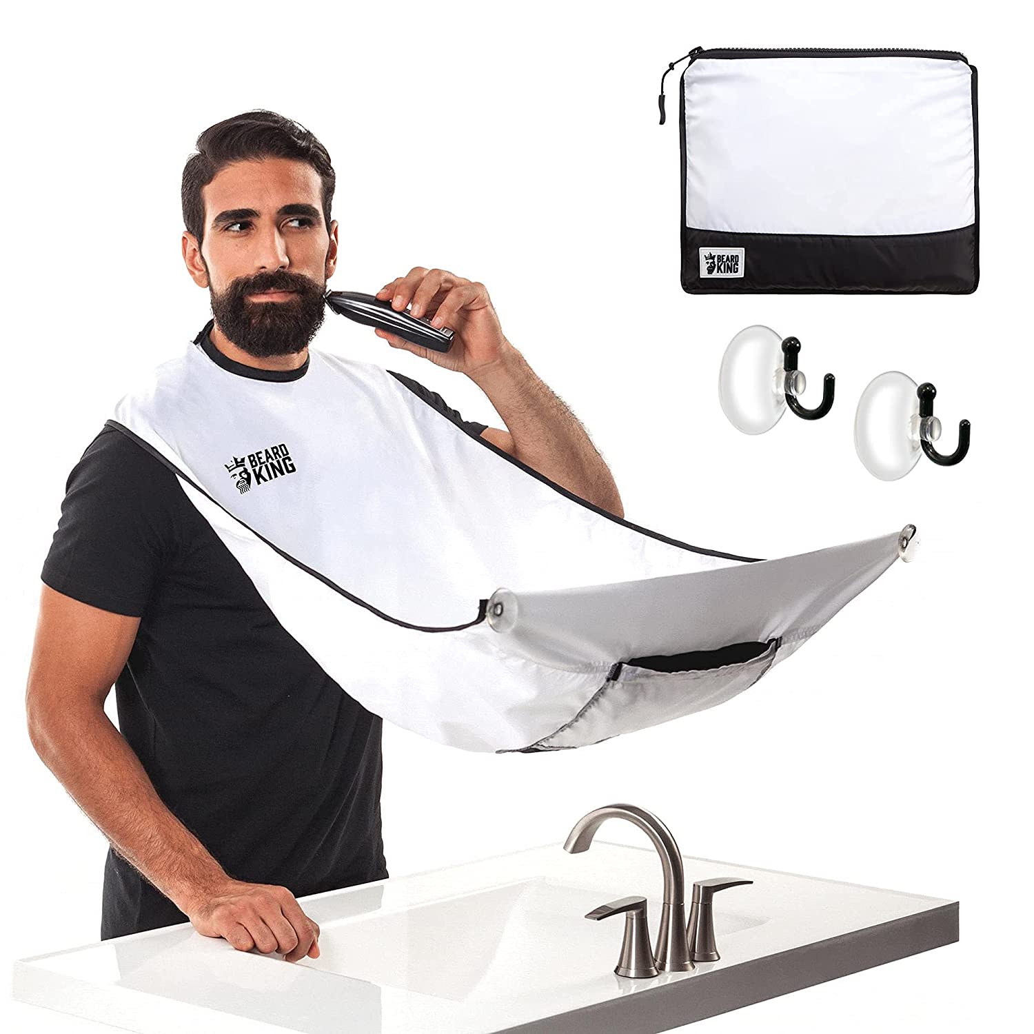 A man is standing in front of a mirror using a beard bib apron and preparing to shave this beard and catch the mess in the apron.
