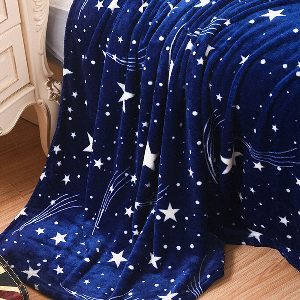 A dark blue blanket draped over a bed. The blanket is covered in white stars.