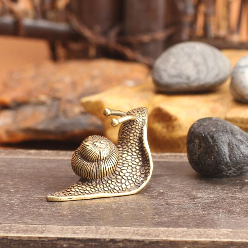 A snail ornament made from pure copper which looks like the snail is crawling away with its head in the air.