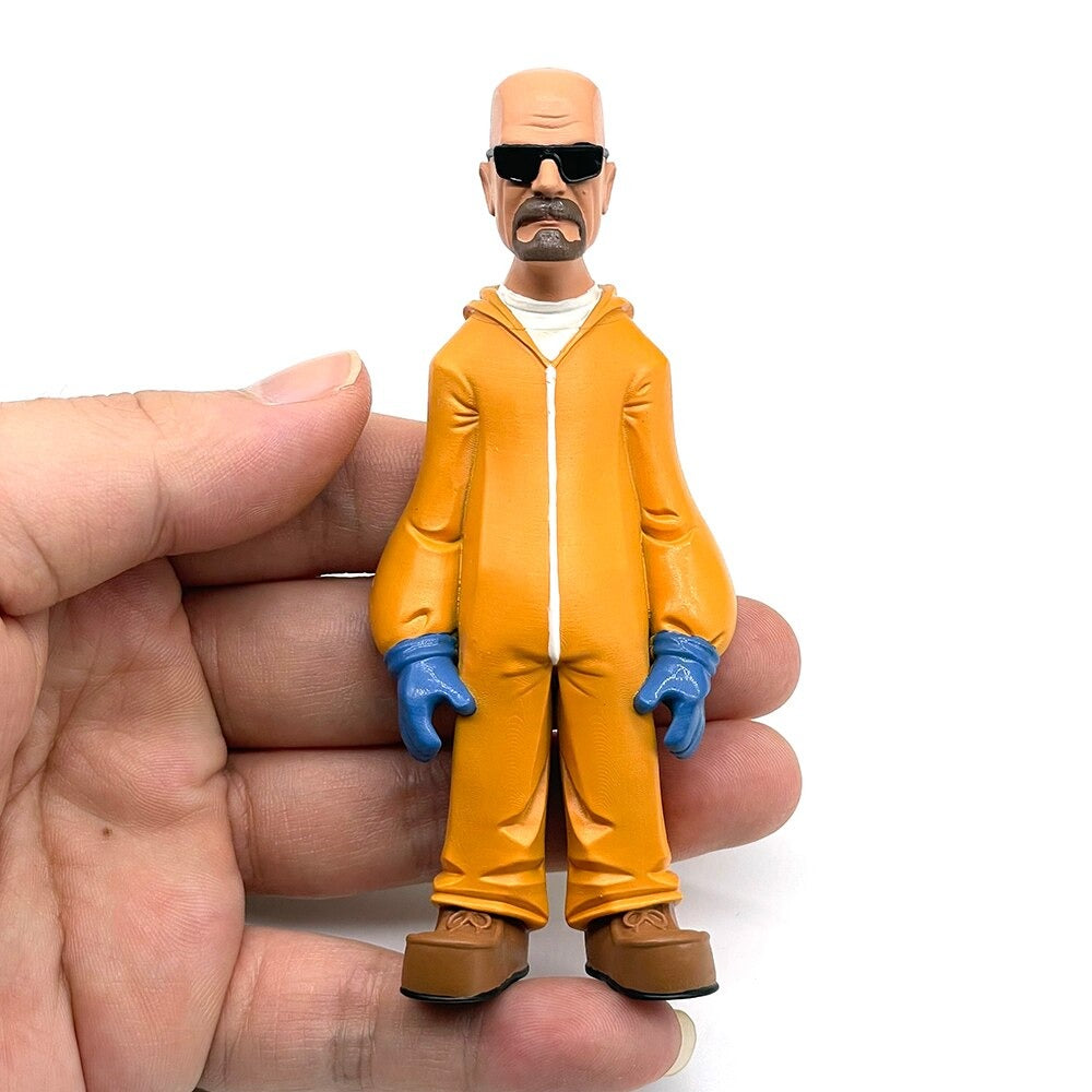 A plastic figurine of Walter White from the TV show Breaking Bad. He is wearing his trademark hazmat suit and sunglasses. The figurine is in the palm of a hand to show the approximate size.