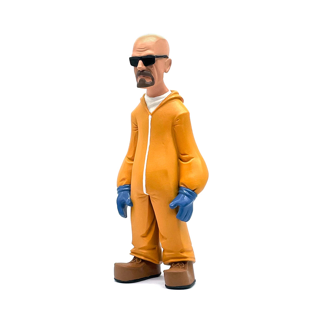 A figurine of Walter White from the TV show Breaking Bad. He is wearing an orange hazmat suit, sunglasses, blue protective gloves and brown boots. He is on a white background at a 45 degree angle.