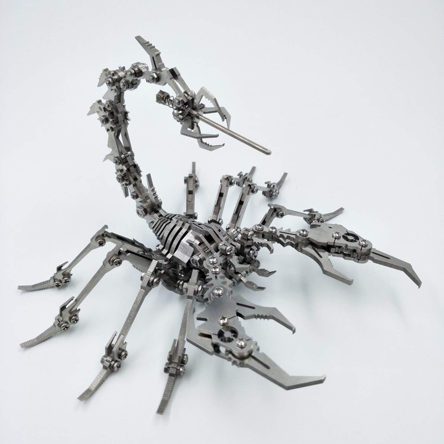 A metal scorpion made from a DIY metal scorpion building kit on a grey background