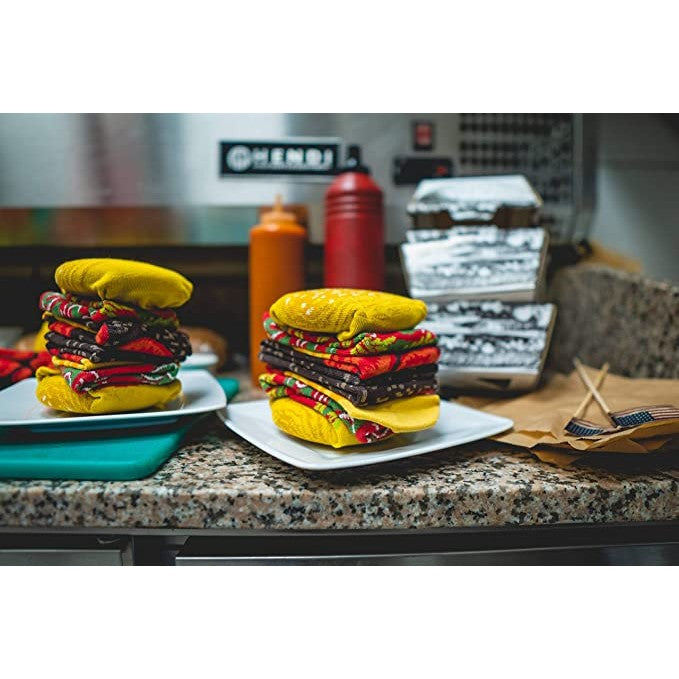Two burger socks are sitting on a pair of plates so they look like real burgers in a restaurant.