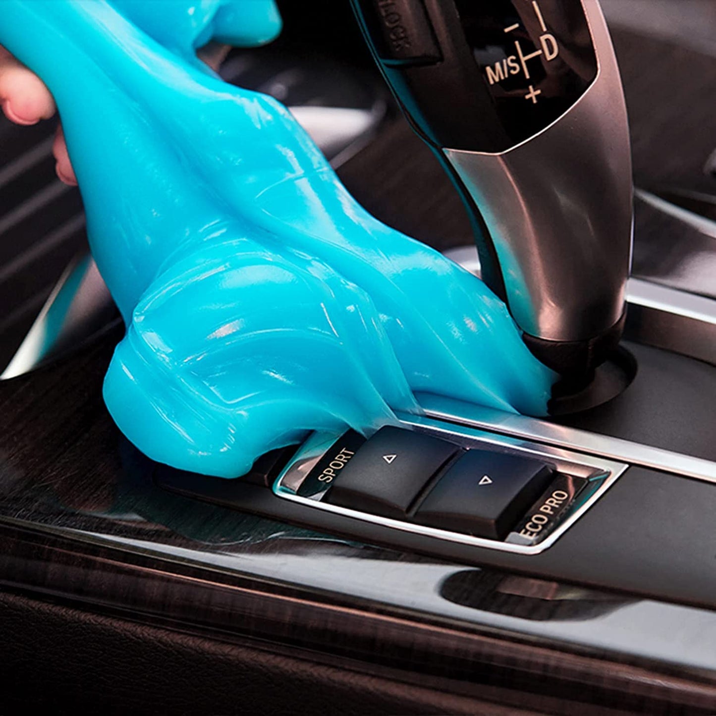 Blue car cleaning gel being used to clean inside a car.