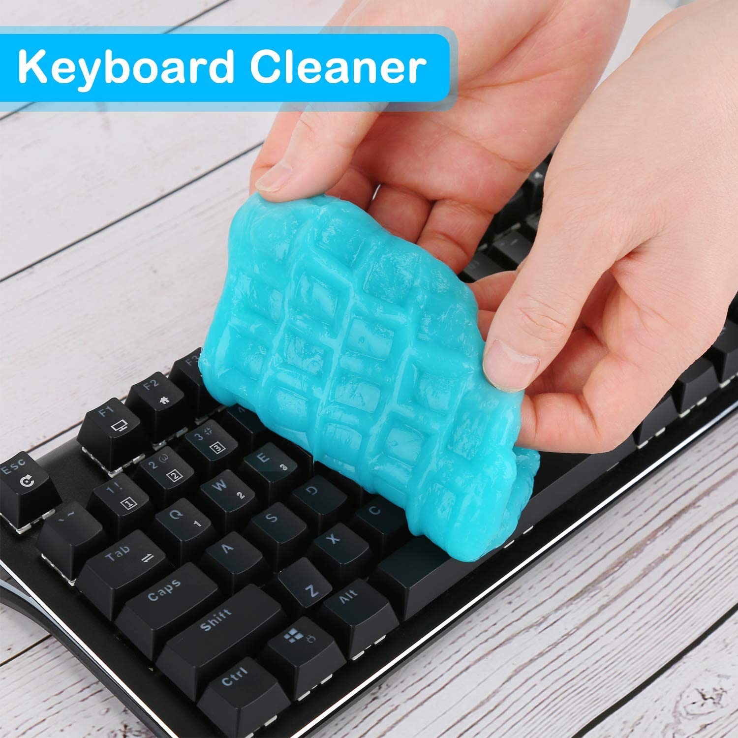 Blue colored cleaning gel being used to pick up dust and dirt off a computer keyboard.