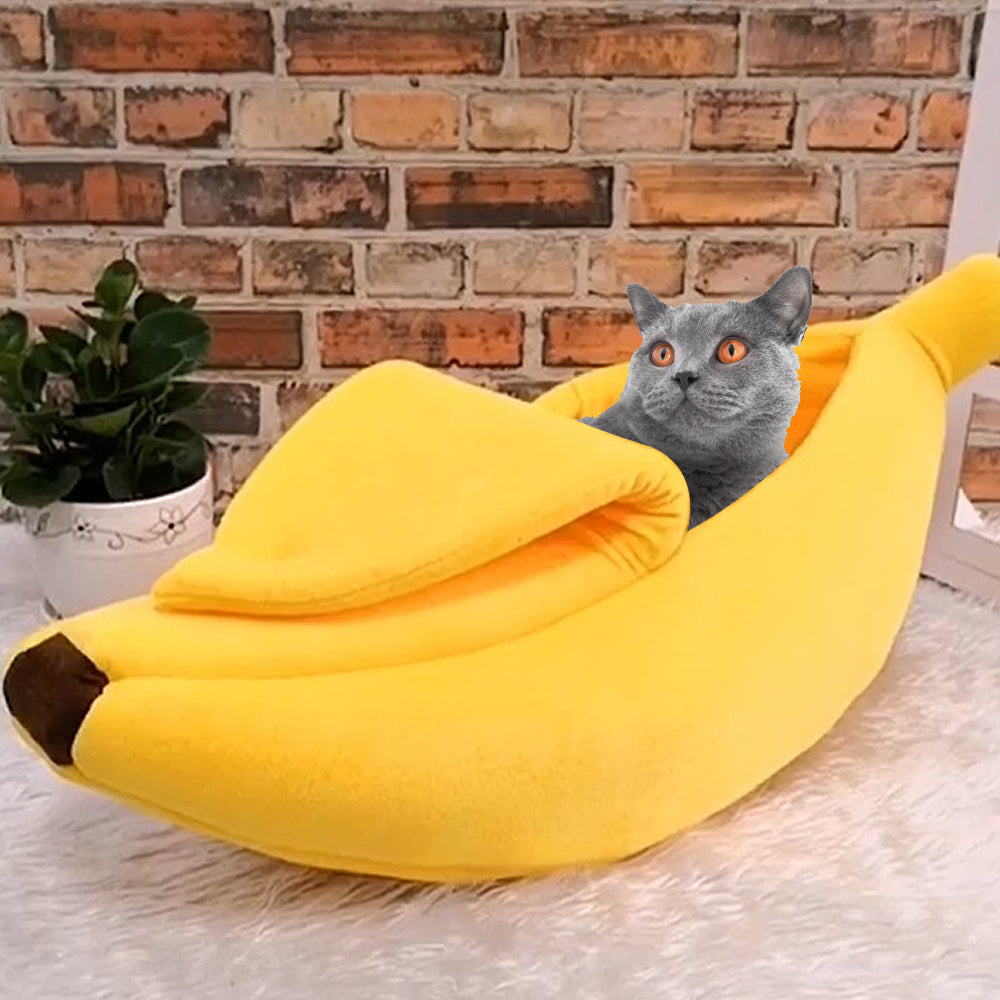 A grey colored cat in a banana shaped cat bed.