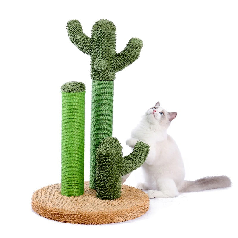A scratching post for cats which is shaped like a green cactus. It has three different poles of varying heights for cats to use. A rag doll kitten is looking up at the scratching post.