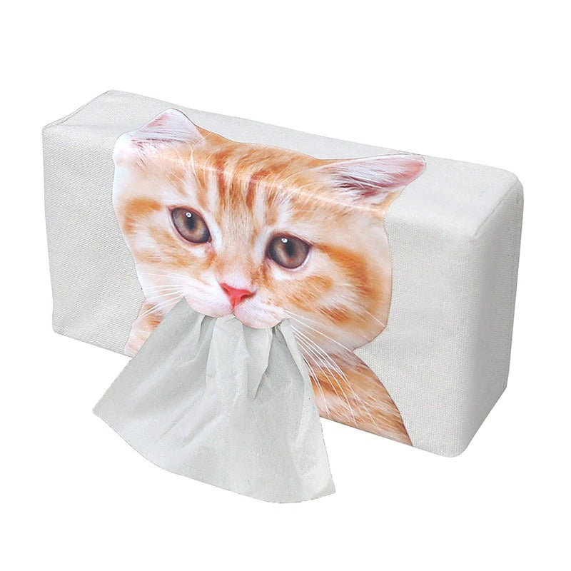 A white tissue box holder which has a ginger kitten's face printed on the front. Tissues are dispensed through the mouth of the kitten.