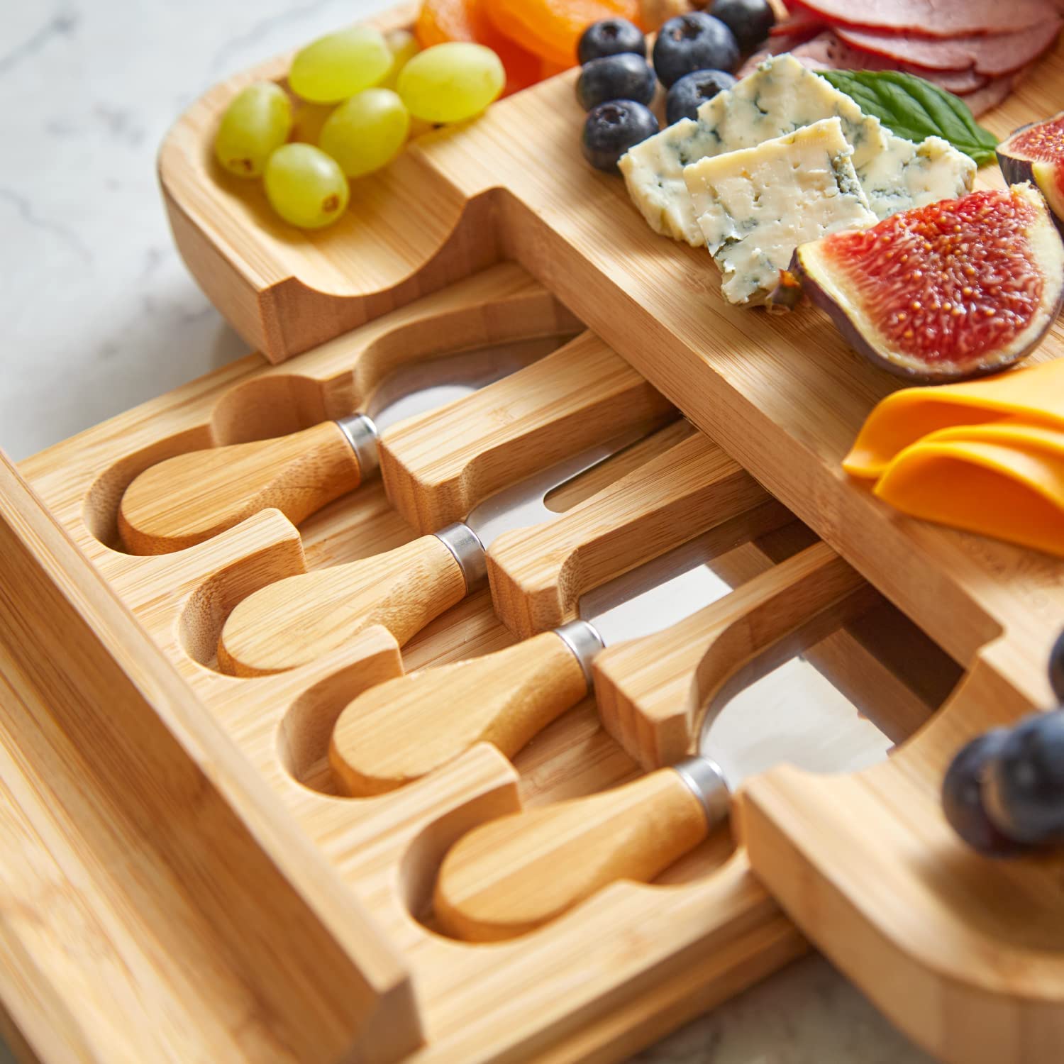 A close-up view of the slide out drawer for a cheese board and knife set with slide-out cutlery drawer