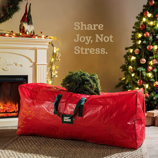 A red Christmas tree storage bag in a lounge room. There is a Christmas tree in the background.