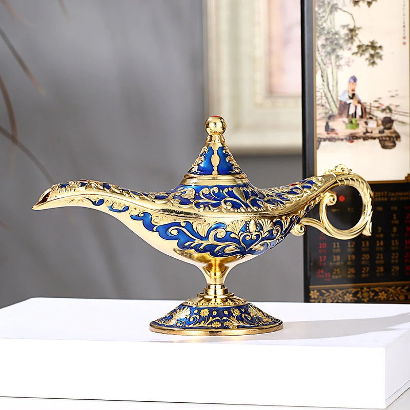 A beautiful gold and blue colored classic magic genie lamp on a white pedestal.