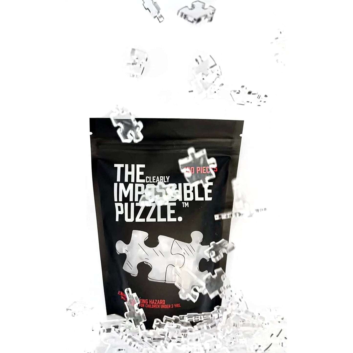 Various pieces of a clear jigsaw puzzle are falling from above in front of the packaging for The Clearly Impossible Puzzle.