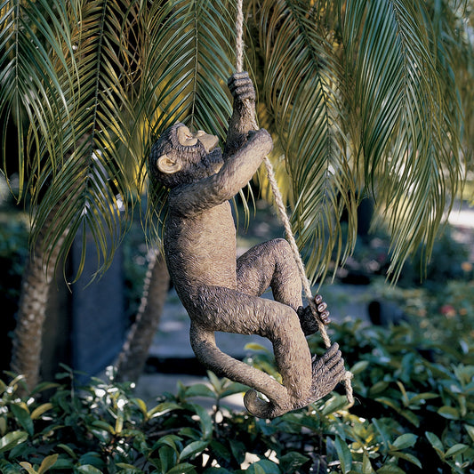 A fake monkey made from resin climbing up a rope