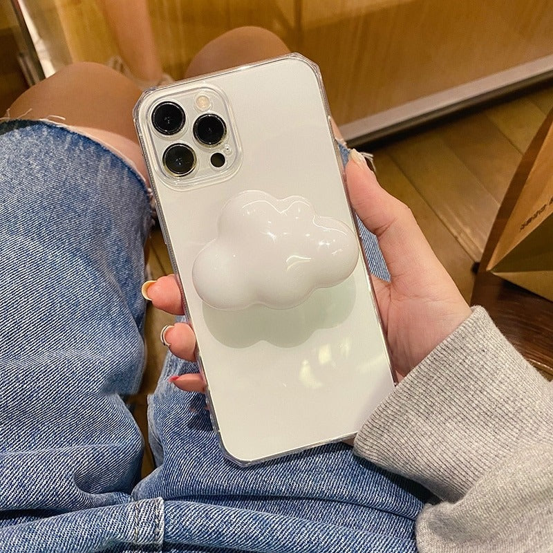 A phone case grip holder which features a white cloud on the back as the grip. The phone is being held in a persons hand.