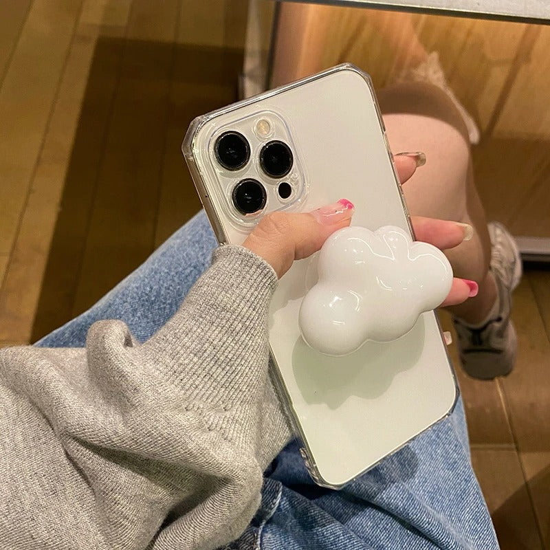 A close-up of a phone case grip holder. The grip holder on the back of the phone case is in the shape of a white cloud.