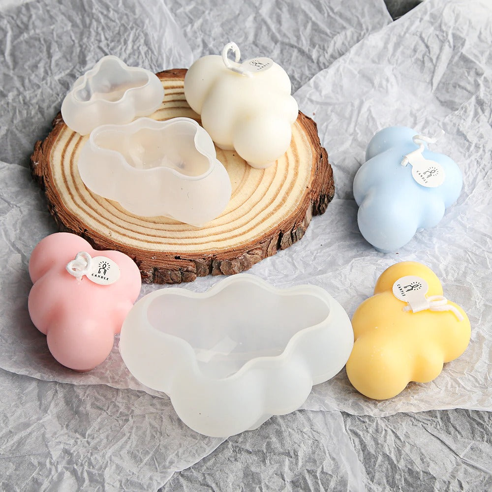 Four cloud shaped candles and a 3 piece set of silicone molds which can be used for candle making.