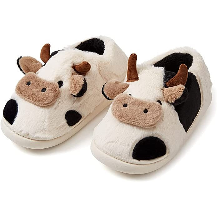 A pair of cute slippers that looks like black and white cows.