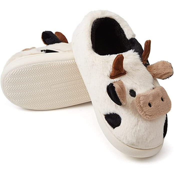 A pair of cow shaped slippers. You can see the front of one of the slippers and the non-slip base on the other.