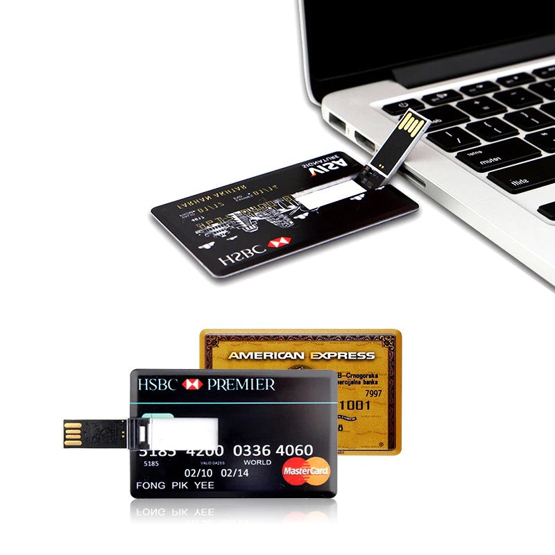 Two HSBC and one gold American Express credit card USB drives.  One of the HSBC cards is leaning against a laptop with the USB drive flipped open ready to use.