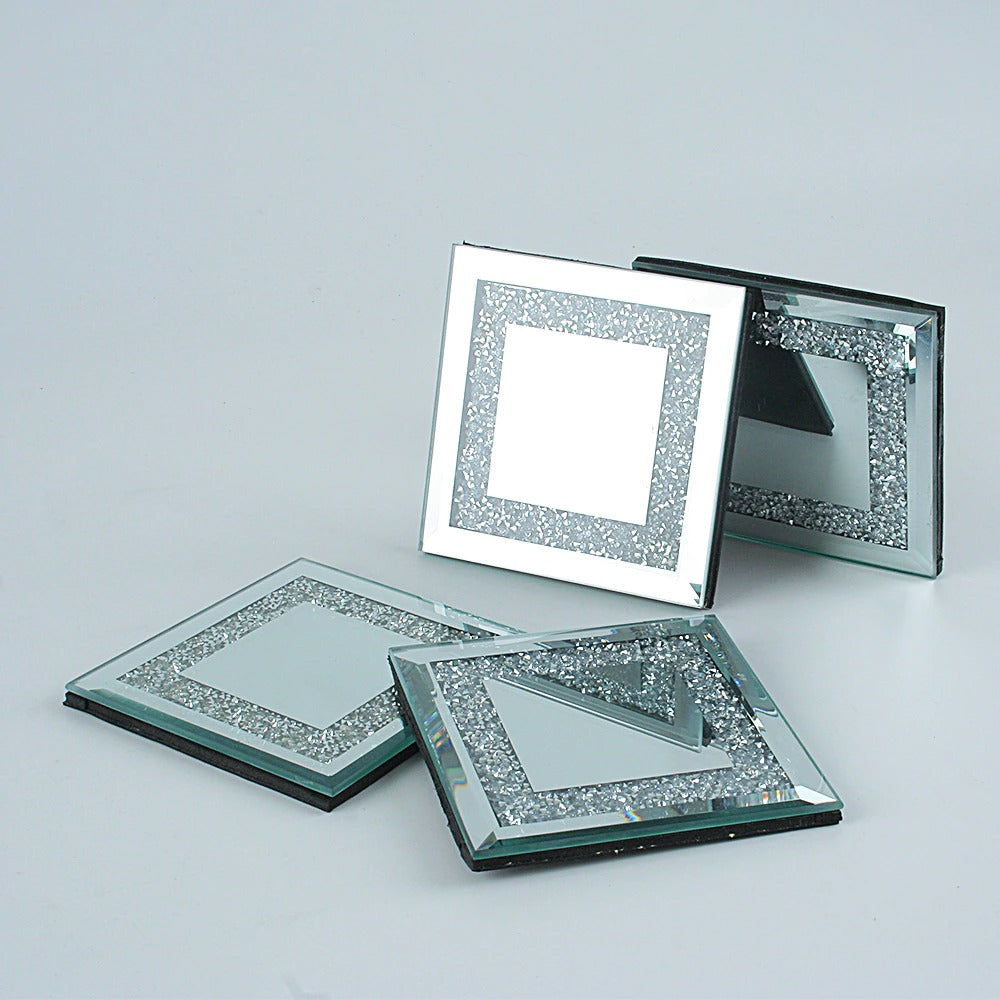 Four square silver coasters, each coaster is filled with tiny, sparking crystals.