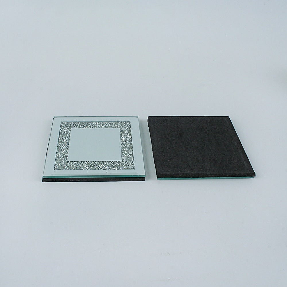 Two silver and crystal coasters. One of the coasters is upside down to show a black base while the other is upright and is filled with tiny crystals.