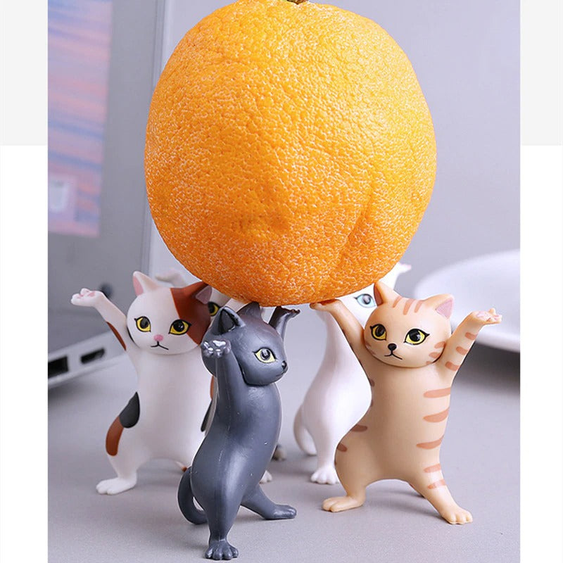 Five dancing cat figurines holding up an orange.