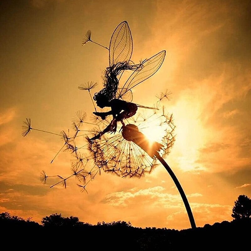 A dancing fairy metal sculpture. The sculpture is in a garden at dusk and as the setting sun hits the sculpture, the outline of the sculpture looks like an actual real fairy leaping over a dandelion.
